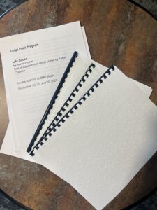 An image of three braille programs arranged on a table top